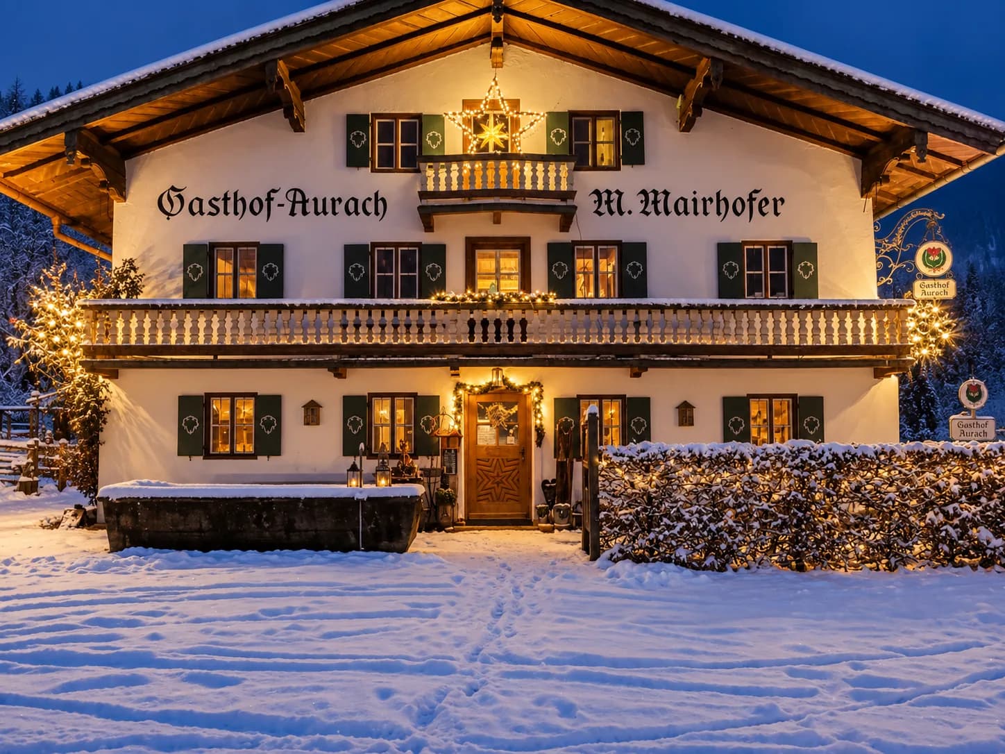 Der weihnachtlich beleuchtete Gasthof in verschneiter Winternacht