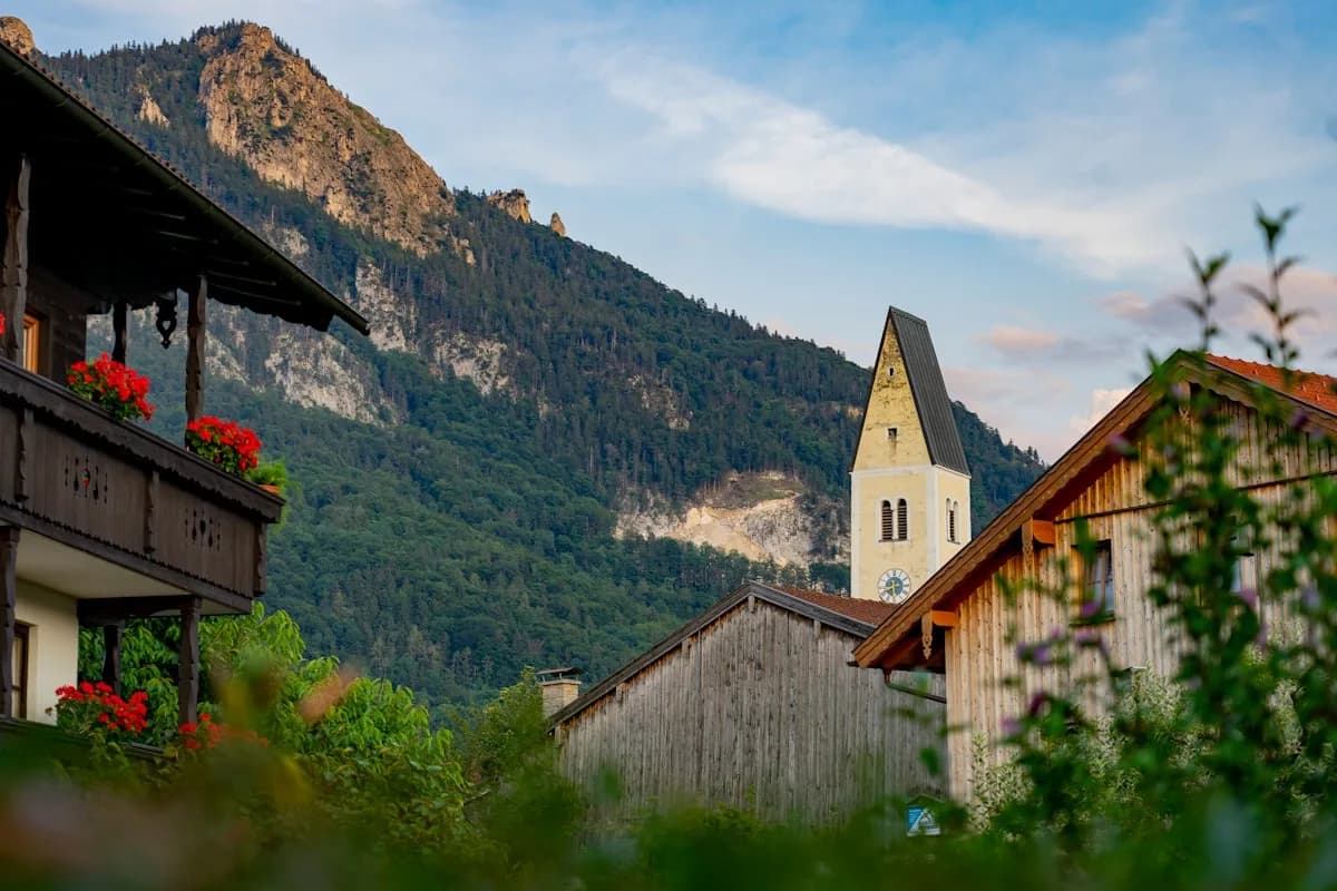 Traditionelles bayerisches Bergdorf mit Kirchturm und Geranien
