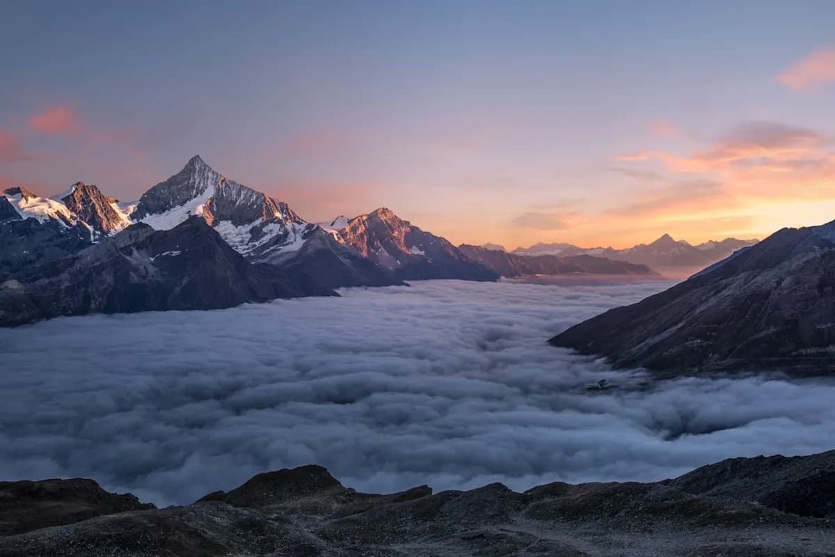 Weiter Blick über Berge und Wolkenmeer bei Sonnenaufgang