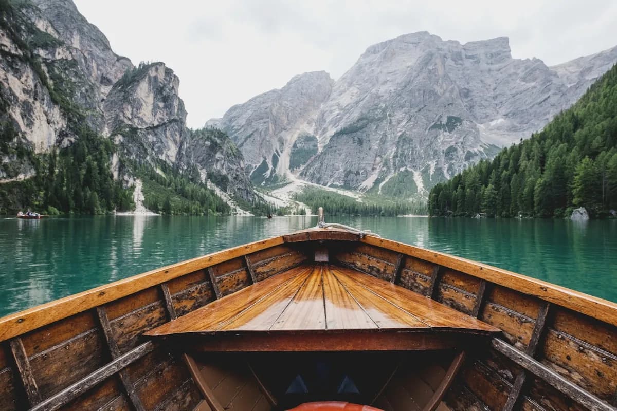 Klarer Bergsee mit Holzboot im Voralpenland